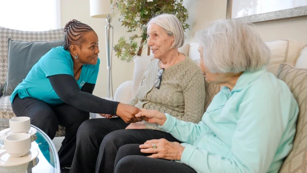 Elderly women having a conversation with a staff member