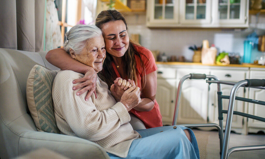 Daughter hugging senior mother at home, showing love and support during home care decision-making