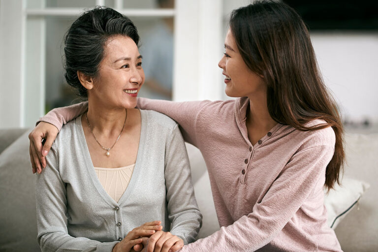 Adult child visiting and checking in on an elderly parent at home